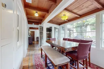 a dining room with a wooden table and chairs at La Jolla Historic Gem, Hot Tub, Game Room, Garden Oasis with Firepit & Courtyard Dining in San Diego