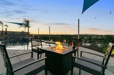 a patio with a table and chairs with a fire pit at Sunset Crest - Home with stunning views, Pool, BBQ in Fallbrook