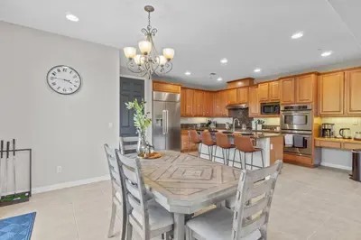 a kitchen with a table and chairs and a clock at Sunset Crest - Home with stunning views, Pool, BBQ in Fallbrook