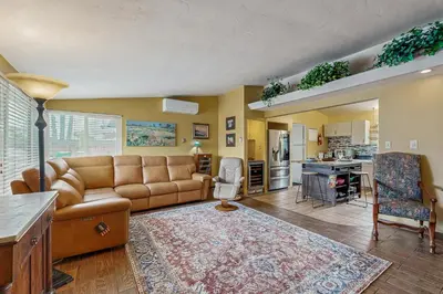 a living room with a couch and a kitchen at Seabreeze Bungalow in Oceanside