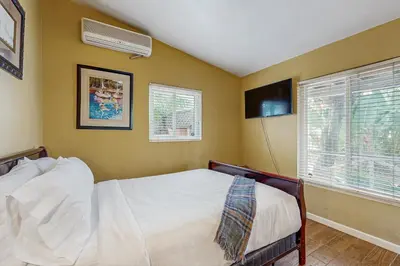 a bedroom with a bed and a window at Seabreeze Bungalow in Oceanside