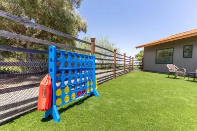 a blue board game on a lawn in front of a fence at Luxury Mountain Estate Sleeps 11 in Valley Center