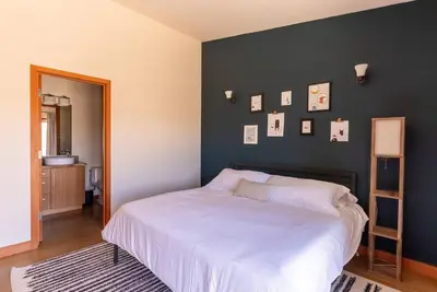 a bedroom with a white bed and a black wall at Luxury Mountain Estate Sleeps 11 in Valley Center