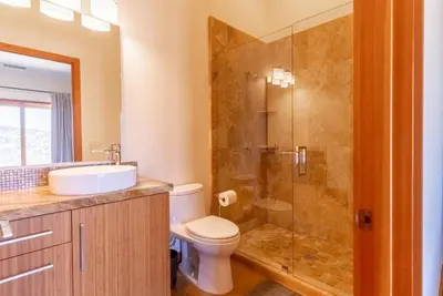 a bathroom with a toilet and a glass shower at Luxury Mountain Estate Sleeps 11 in Valley Center