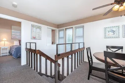 a room with a staircase and a table and a bed at Retro 3Br With Oceanview Patio In A Very Walkable Location By Beachview Rentals in Newport Beach