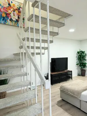 a white spiral staircase in a living room with a tv at Amazing house in La Jolla in San Diego