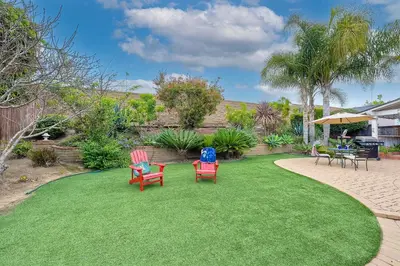 a yard with chairs and tables on a lawn at Carlsbad Charm - 3BR Stunner in Carlsbad