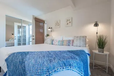 a bedroom with a large bed with a blue and white blanket at Family Retreat - Legoland & Beach in Oceanside