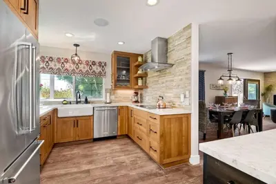 a large kitchen with wooden cabinets and a table at Fresh & Modern 3BR - Just Blocks from Beach in Encinitas