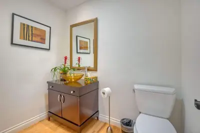 a bathroom with a toilet and a sink and a mirror at Serene Coastal Home Sleeps 8 - 1 Mile from Beach in Encinitas