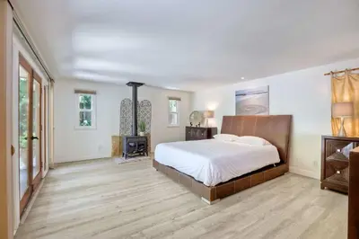 a large bedroom with a large bed and wooden floors at Serene Coastal Home Sleeps 8 - 1 Mile from Beach in Encinitas
