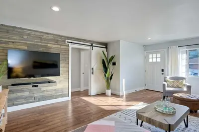 a living room with a tv on a wall at Immaculate 3 BDR in Oceanside - Private Pool & Spa in Oceanside