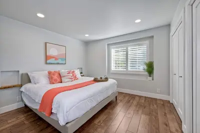 a white bedroom with a large bed with orange sheets at Immaculate 3 BDR in Oceanside - Private Pool & Spa in Oceanside