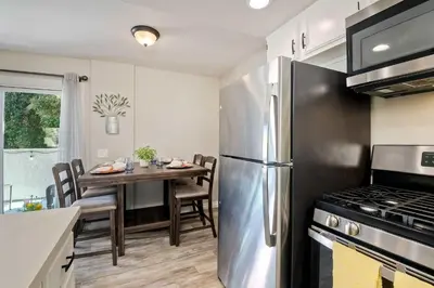 a kitchen with a table and a stainless steel refrigerator at Silver Surf Getaway in Oceanside