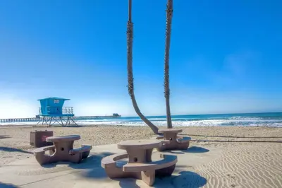 a group of benches on the beach near the ocean at Silver Surf Getaway in Oceanside