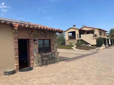 a building with a patio with two chairs in front of it at Casita Vino Dog-Friendly Vineyard Retreat & Stay in Escondido