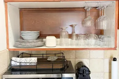 a kitchen shelf with glasses and dishes on it at Casita Vino Dog-Friendly Vineyard Retreat & Stay in Escondido
