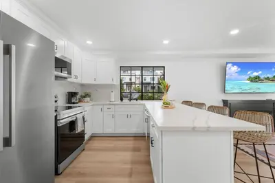 a kitchen with white cabinets and a large island at Walk to Mission Bay Firepit AC Putting Green in San Diego