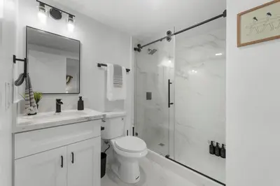 a white bathroom with a shower and a toilet at Walk to Mission Bay Firepit AC Putting Green in San Diego