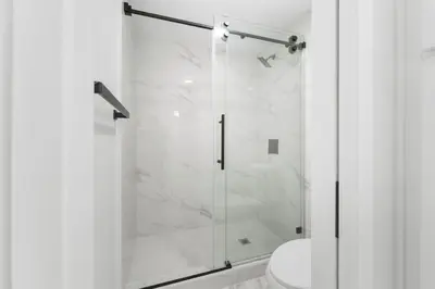 a bathroom with a glass shower with a toilet at Walk to Mission Bay Firepit AC Putting Green in San Diego