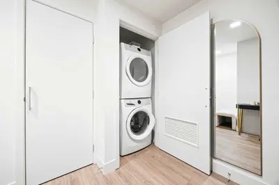 a white laundry room with a washer and dryer at Penthouse High-Rise Ocean & City Views in San Diego