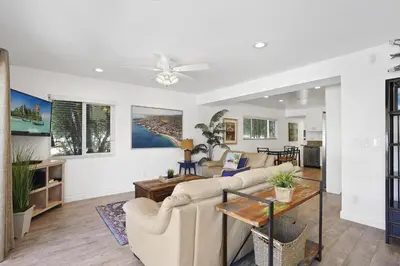 a living room with couches and a table at Cozy 2Br Oceanview, Half Block To Popular 29Th St Beach By Beachview Rentals in Newport Beach