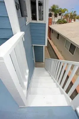 a stairway leading up to a blue building at Cozy 2Br W Ac And Private Patio, Steps To 40Th St Beach By Beachview Rentals in Newport Beach