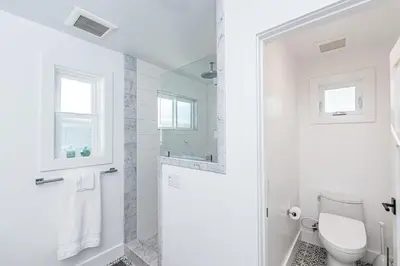 a white bathroom with a toilet and a sink at 3Br Luxury Condo W Rooftop Deck, Fire Pit, Steps To Sand By Beachview Rentals in Newport Beach