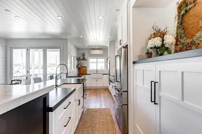 a large kitchen with white cabinets and a sink at 3Br Luxury Condo W Rooftop Deck, Fire Pit, Steps To Sand By Beachview Rentals in Newport Beach