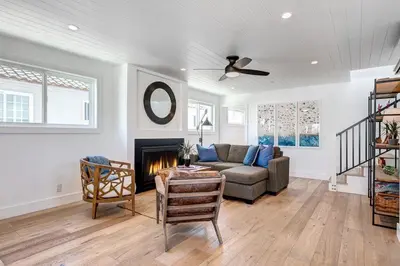a living room with a couch and a fireplace at 3Br Luxury Condo W Rooftop Deck, Fire Pit, Steps To Sand By Beachview Rentals in Newport Beach