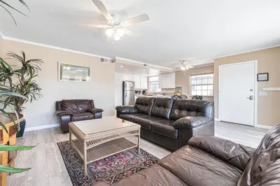 a living room with leather furniture and a ceiling fan at Pet-Friendly 3Br W Ac, Rooftop Deck, 2 Houses From Beach By Beachview Rentals in Newport Beach