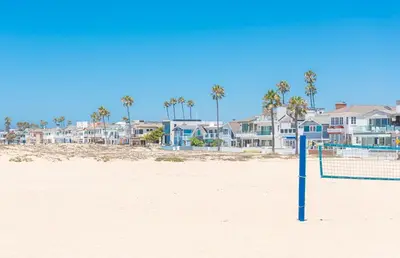 a volleyball net on the beach with houses at Pet-Friendly 3Br W Ac, Rooftop Deck, 2 Houses From Beach By Beachview Rentals in Newport Beach