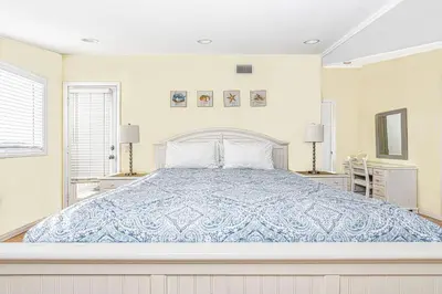 a bedroom with a bed with a blue comforter at Family-Friendly 3Br Steps From Beach - Walk To Everything By Beachview Rentals in Newport Beach