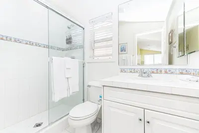 a white bathroom with a toilet and a sink at Family-Friendly 3Br Steps From Beach - Walk To Everything By Beachview Rentals in Newport Beach