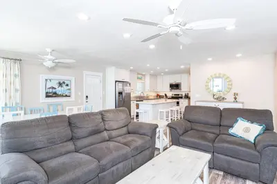 a living room with two couches and a kitchen at Upgraded 5Br Summer Vacation Home, Steps From The Sand By Beachview Rentals in Newport Beach