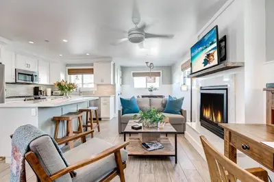 a kitchen and living room with a couch and a fireplace at Luxury 4Br Coastal Retreat W Rooftop Deck And Ocean Views By Beachview Rentals in Newport Beach