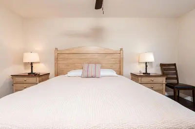 a bedroom with a large white bed with two night stands at Spacious 4Br Retreat W Rooftop Deck One Block From Beach By Beachview Rentals in Newport Beach