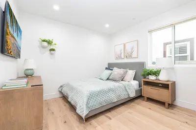 a white bedroom with a bed and a table at Luxury 3Br W Rooftop Deck, Grill, Ac, Steps From The Sand By Beachview Rentals in Newport Beach