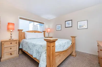 a bedroom with a wooden bed and a window at 3Br Oceanfront In Desirable Location At Excellent Value By Beachview Rentals in Newport Beach