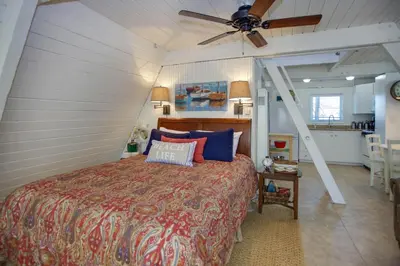 a bedroom with a bed and a ceiling fan at Retro A-Frame Studio W Loft And Sun Deck, Steps From Sand By Beachview Rentals in Newport Beach