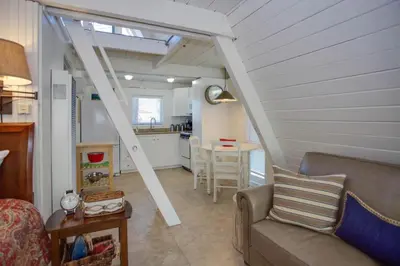 a living room with a couch and a table at Retro A-Frame Studio W Loft And Sun Deck, Steps From Sand By Beachview Rentals in Newport Beach