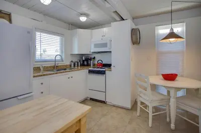 a kitchen with white cabinets and a table with a bowl on it at Retro A-Frame Studio W Loft And Sun Deck, Steps From Sand By Beachview Rentals in Newport Beach
