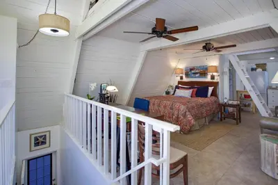 a bedroom with a bed and a ceiling fan at Retro A-Frame Studio W Loft And Sun Deck, Steps From Sand By Beachview Rentals in Newport Beach