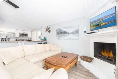 a living room with a white couch and a fireplace at 3Br Beach Cottage W Large Patio And Grill, Prime Location By Beachview Rentals in Newport Beach