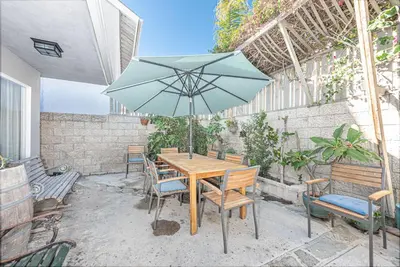 a table and chairs with an umbrella on a patio at Affordable 3Br Near Beach, Walk To Shops, Dining And More By Beachview Rentals in Newport Beach
