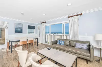 a living room with a couch and a table at Modern 3Br Oceanfront W Rooftop Deck And Panoramic Views By Beachview Rentals in Newport Beach