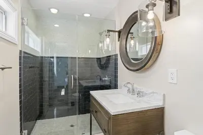 a bathroom with a shower and a sink and a mirror at Modern 3Br Oceanfront W Rooftop Deck And Panoramic Views By Beachview Rentals in Newport Beach