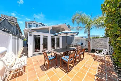 a patio with a table and chairs on a brick patio at Spacious 6Br W Oceanview And Garden Patio, Steps To Sand By Beachview Rentals in Newport Beach