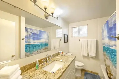 a bathroom with a sink and a toilet and a mirror at Spacious 6Br W Oceanview And Garden Patio, Steps To Sand By Beachview Rentals in Newport Beach