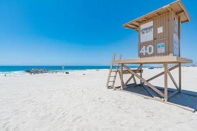 a lifeguard station on a beach with the ocean at 3Br Bayfront W Expansive Front Patio - Easy Walk To Beach By Beachview Rentals in Newport Beach